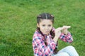 Kid gadabout. Girl little kid spend leisure outdoors in park. Girl sit on grass in park. Child enjoy spring sunny Royalty Free Stock Photo