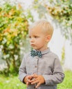 Kid gentleman style. Boy with bowtie on garden background.