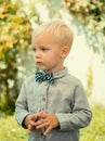 Kid gentleman style. Boy with bowtie on garden background.