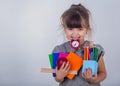 Kid gets ready for school. Schoolgirl holding many school supplies: pens, notebooks, scissors and apple. Back to school concept. Royalty Free Stock Photo