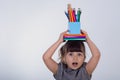 Kid gets ready for school. Schoolgirl holding many school supplies: pens, notebooks, scissors and apple. Back to school concept. Royalty Free Stock Photo