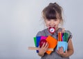 Kid gets ready for school. Schoolgirl holding many school supplies: pens, notebooks, scissors and apple. Back to school concept. Royalty Free Stock Photo