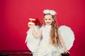 Kid girl angel with present gift, studio portrait. Little angel with white wings holds gift, happy fairy. Cute angel Royalty Free Stock Photo