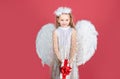 Kid girl angel with present gift, studio portrait. Little angel with white wings holds gift. Cute angel child girl with Royalty Free Stock Photo