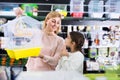 Kid girl begging her mother to buy bird cage Royalty Free Stock Photo