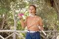 Kid girl blowing soap bubbles in a park in a sunny day