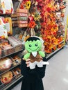 Kid girl choosing toy in store for Halloween holiday celebration.