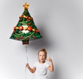 Kid girl with christmas tree air balloon is showing attention important sign gesture on white with free copy space.