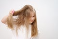 kid girl combs long and tangled hair. white background.