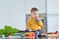 Kid girl eating healthy vegetables at kitchen Royalty Free Stock Photo