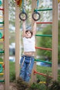 Kid girl hanging on the rings on kid playground