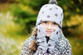 Kid girl has fun in garden with first snow