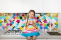 Kid girl having fun at kitchen. Colorful interior