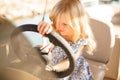 Kid girl at helm of boat on pier. travel on water.