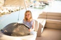 Kid girl at helm of boat on pier. travel on water.