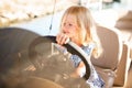 Kid girl at helm of boat on pier. travel on water.