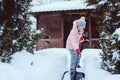 kid girl helping to clean pathway from snow with showel Royalty Free Stock Photo