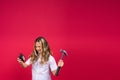 Kid girl holding hammer and alarm clock smiling with a happy and cool smile on face. showing teeth. Royalty Free Stock Photo