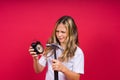 Kid girl holding hammer and alarm clock smiling with a happy and cool smile on face. showing teeth. Royalty Free Stock Photo