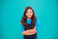 Kid girl long hair posing confidently. Girl curly hairstyle feels confident. Child hold hands confidently crossed chest Royalty Free Stock Photo