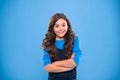 Kid girl long hair posing confidently. Girl curly hairstyle feels confident. Child hold hands confidently crossed chest Royalty Free Stock Photo