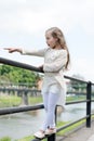 Kid girl with long hair walks near riverside, river on background. Girl child tourist enjoy sightseeing while walks Royalty Free Stock Photo