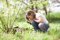 Kid girl with magnifying glass explores grass