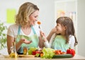 Kid girl and mother eating healthy food vegetables Royalty Free Stock Photo