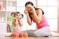 Kid girl and mother have a fun with puzzle toys. Young woman and child toddler sitting on floor and playing educational Royalty Free Stock Photo