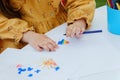 Kid girl painting with colored pencil. Kindergarten children education concept.