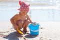 Kid girl play on a beach. Child building sand castle on beach. Summer water fun for family. Girl with toy buckets and spade at the Royalty Free Stock Photo