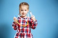 Kid girl playing doctor with syringe and stethoscope on a blue background. Royalty Free Stock Photo