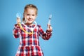 Kid girl playing doctor with syringe and stethoscope on a blue background. Royalty Free Stock Photo