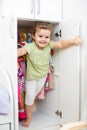 Kid girl playing and hiding inside wardrobe Royalty Free Stock Photo