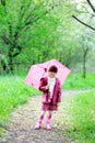 Kid girl posing outdoors with pink umbrella Royalty Free Stock Photo