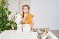 kid girl prepares dough in submersible mixer, tries and it tastes unpalatable