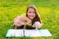 Kid girl and puppy dog at homework lying in lawn Royalty Free Stock Photo