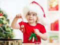 Kid girl in Santa hat holding Christmas cookies Royalty Free Stock Photo