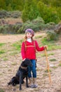 Kid girl shepherdess happy with dog and flock of sheep