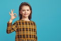 Kid girl shows okay sign or all right gesture, recommends good product Royalty Free Stock Photo