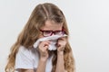 Kid girl sneezes in handkerchief. Flu season, white backgroud, copy space.
