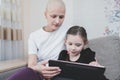 Kid girl spend time with his mother with a diagnosis of leukemia at home. Family support concept