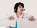 Kid girl with stethoscope checking to a bear toy plays a doctor. children`s games. In white coat and stethoscope. Adorable child Royalty Free Stock Photo