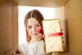 kid girl, teenager, unpacking and opening carton box, and looking inside with surprise Royalty Free Stock Photo