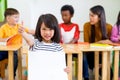 Kid girl thumbs up and holding blank white poster with diversity