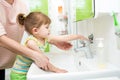 Kid girl washing hands with soap in bathroom Royalty Free Stock Photo