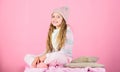 Kid girl wear knitted soft hat pink background. Keep knitwear soft after washing. Soft knitted accessory. Tips for Royalty Free Stock Photo