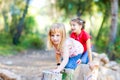 Kid girls playing on trunks in forest nature