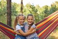 Kid girls relax in colorful rainbow hammock Royalty Free Stock Photo