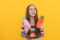 kid in glasses holding shower gel. happy teen girl use shampoo bottle. child with hair conditioner Royalty Free Stock Photo